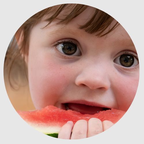 Une petite fille qui mange une pastèque